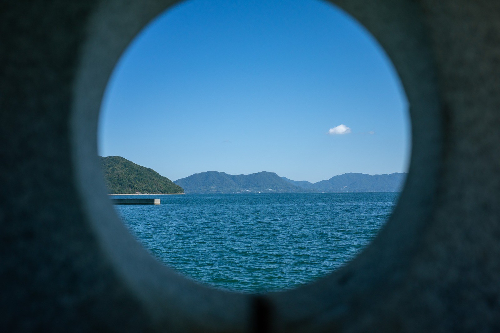 丸い開口越しに見える瀬戸内海と島