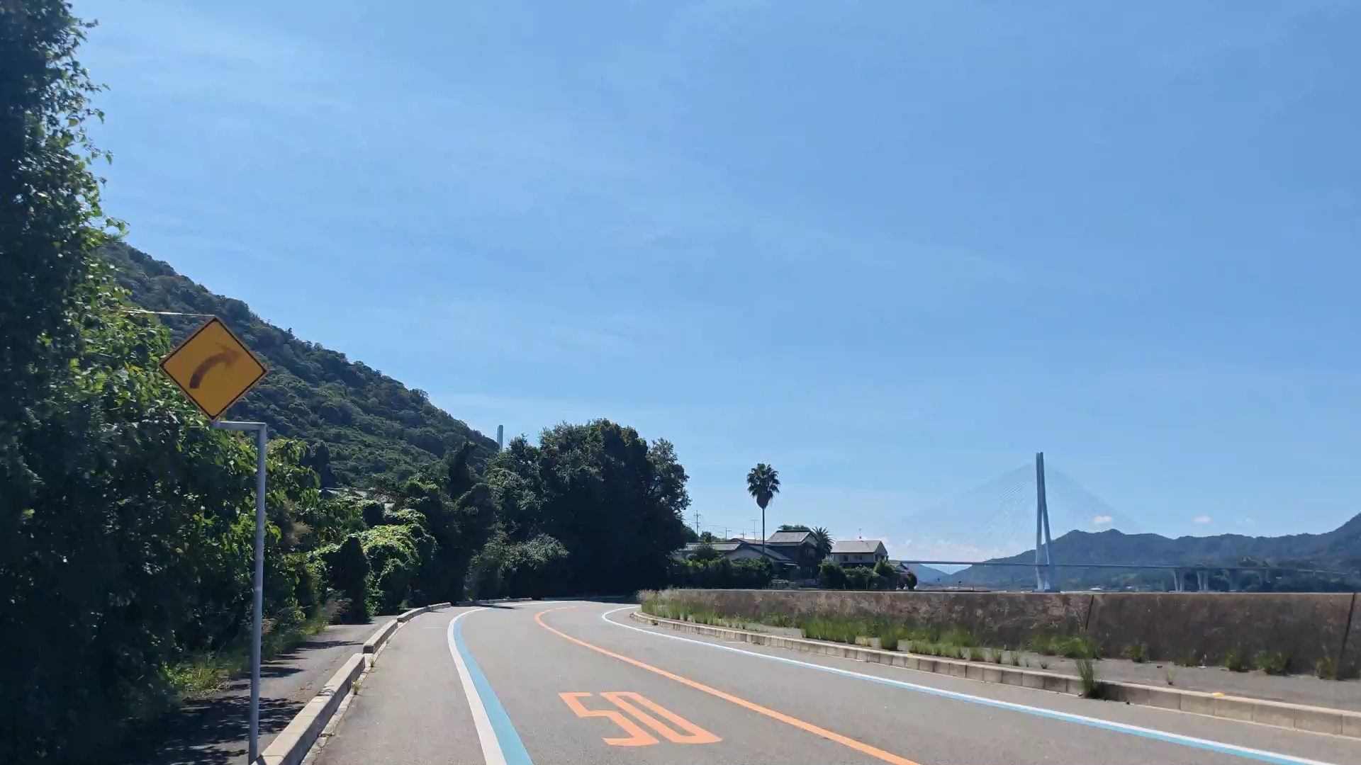 海沿いの道路と遠方の斜張橋。